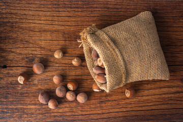 Hazelnuts in a linen bag on a wooden table.