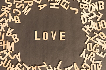 Love Word In Wooden Cube Alphabet Letters Top View On A rustic paper Background.