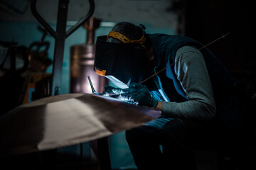 Heavy industry worker welding steel with electric appliance.