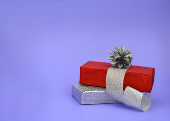 Gift shiny silver and red box with ribbon and pine cone. Christmas, New Year. Copy space