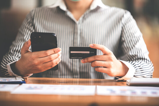 female hand holding phone and credit card