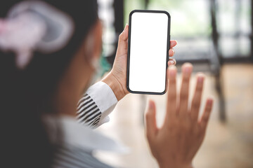 Cropped image of a female freelance translator's hand. holding a blank screen smartphone in his modern workplace