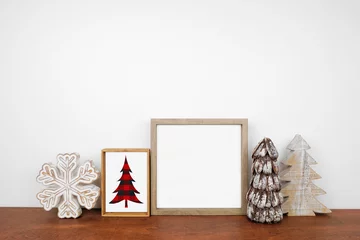  Christmas mock up with wood frame, rustic decor and buffalo plaid sign. Square frame on a wood shelf against a white wall. Copy space. Modern farmhouse concept. © Jenifoto