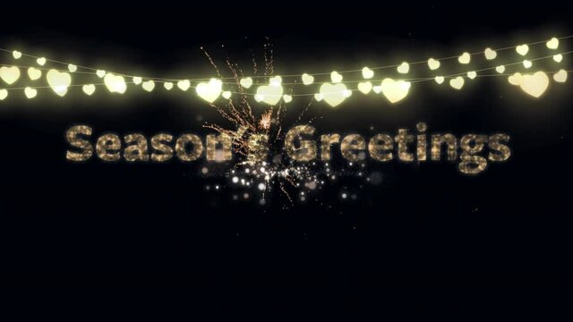 Animation of gold text season's greetings, with string of heart fairy lights and fireworks, on black