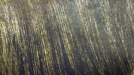 The worn, old surface is black with yellowed, vertical stripes. Vintage background.
