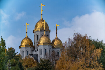 The Church of All Saints on Mamayev Kurgan in Volgograd, Russia. Golden domes of a Christian church in yellow autumn foliage