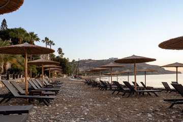 Among the sun loungers on the beach of sand and pebbles, against the backdrop of sailing catamarans
