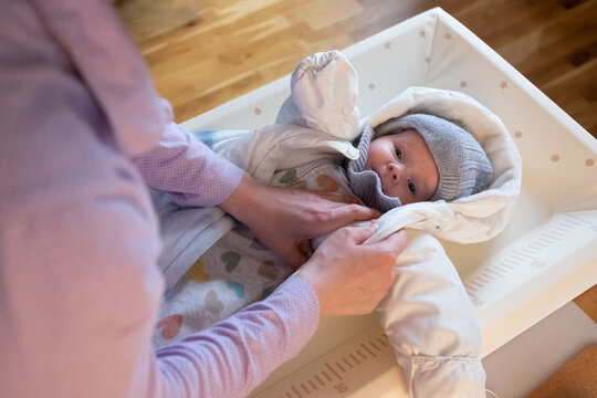 Putting On Warm Clothes On Baby Girl Preparing For A Walk On Cold Winter Day.