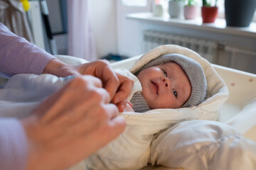 putting on warm clothes on baby girl preparing for a walk on cold winter day.