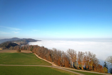 Aerial perspective of autumn landscape with sea of fog at region of Uetliberg Albis at Canton Zürich on a beautiful sunny day. Photo taken November 12th, 2021, Zurich, Switzerland.