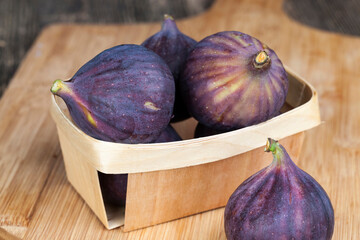ripe purple figs on a wooden table