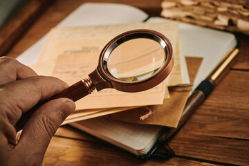 Fototapeta premium Exploring antique documents through the magnifying glass