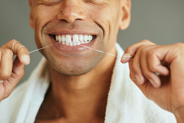Close-up of man cleans his teeth with dental floss.