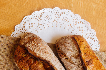 Two pieces of French baguette on a pad and a white