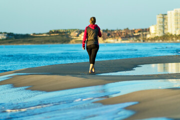Woman walking along the seashore in an urban setting