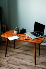 Workplace of photographer, laptop, diary, pen, coffee, power bank, vintage camera on wooden office desk background