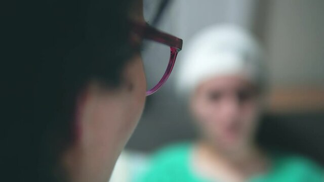 Doctor talks to patient with head injury at clinic, selective focus