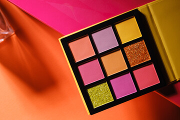 Eyeshadow Palette with nine bright, metallic, and matte shades at colorful background