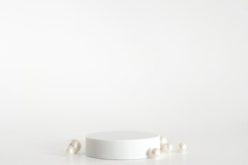 White podium with pearls on the white background, simple geometric form. Podium for product,...