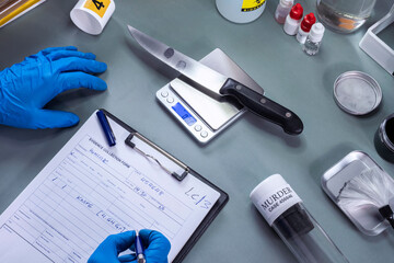 crime police weigh knife involved in murder, record data in crime lab, concept image