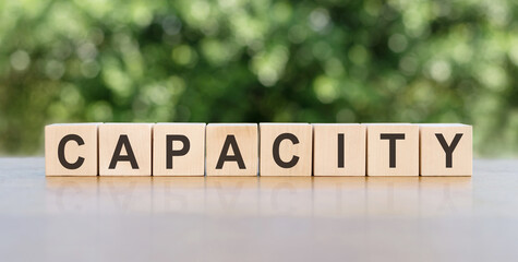 CAPACITY word made with cubes on a green background