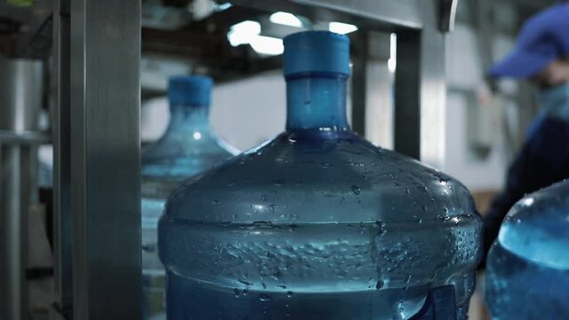 Production. Filling open necks of PET bottles with water. Large empty plastic bottle. 5 Gallon Refillable Bottles Clean Water Bottle On Conveyor.
