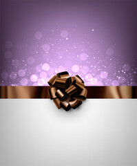 Brown foil ribbon with beautiful bow on purple bokeh background.