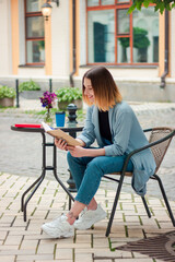 Confident beautiful girl with a notebook on the terrace. Business style. Psychologist