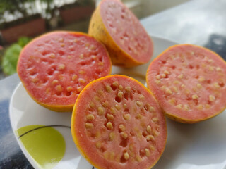 Background of ripe guava served on a plate in a bistro or garden. 