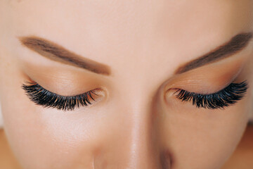 Eyelash Extension Procedure. Woman Eye with Long Eyelashes. Close up, selective focus. - 468845890