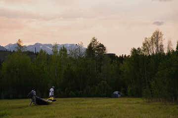 People carrying boat through meadow trees mountain