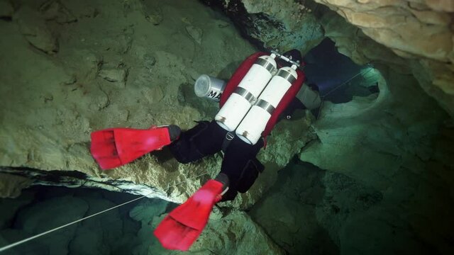 Budapest - 17 August 2017: Technical diver in red flippers in the underwater cave of Budapest