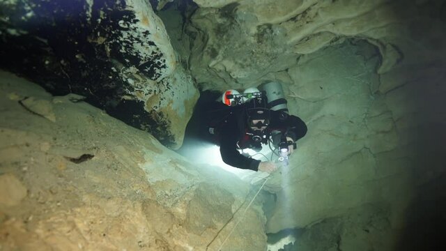 Budapest - 17 August 2017: Technical diver in red flippers in the underwater cave of Budapest
