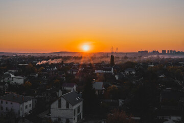 Houses and tall buildings on the horizon in sunset. Place. Scene. Village. View. Lights