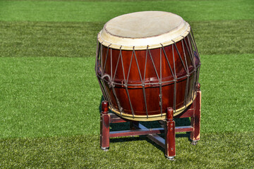 big ethnic drum on a stand on green grass
