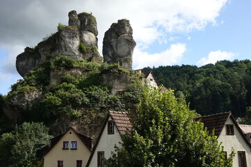 Fototapeta premium Famous rocks with lookout point Fahnenstein over traditional German framework houses, Tüchersfeld, Pottenstein, Upper Franconia, Bavaria, Germany 