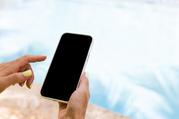 Female hand holding smartphone and typing with index finger. Closeup, mock up.