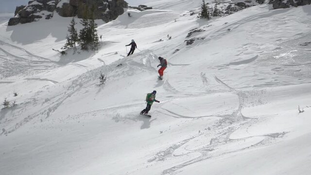 Freerider skier skiing in deep powder snow off-piste, downhill from the mountain peak, extreme winter sport, slow motion