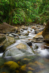 slow shutter speed of soft water and rocks river in jungle 