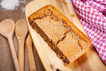 Piece of homemade semolina cake on wooden cutting board. Close up
