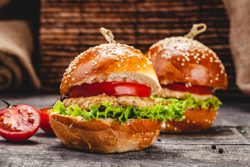 Chicken burgers on wooden background. Close up