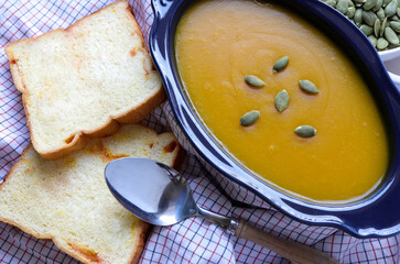 Autumn pumpkin cream soup on the table. Seasonal autumn food.