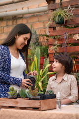Mother and son doing gardening chores. Latin single mother. Healthy family relationship.