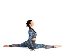 Beautiful sportive woman is engaged in fitness. Sits in a twine on an isolated white background. Sports and healthy lifestyle