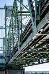 Riveted frame of a powerful sectional arched lifting transport bridge on concrete supports over the...