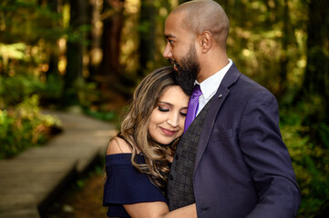 Fototapeta premium Full of love photo of an affectionate mixed race young couple holding each other in the woods