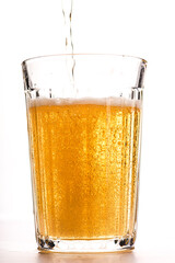 light beer in a faceted glass with foam on a white background isolated
