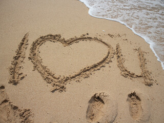 Write I love you in the beach with sea wave
