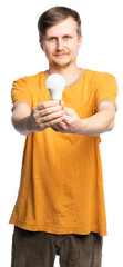 a man in a torn orange T-shirt and old corduroy brown pants holds a light bulb with both hands,...