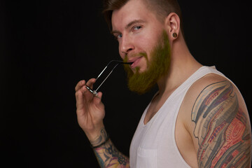 bearded man in white t-shirt with tattoos on his arms posing bully
